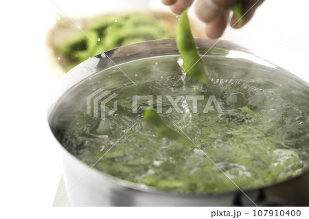 枝豆を鍋で茹でる 酒の肴に（ お酒のおつまみイメージ ）えだまめの塩茹で 豆 枝まめ 白バック ボイ 107910400