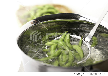 枝豆を鍋で茹でる 酒の肴に（ お酒のおつまみイメージ ）えだまめの塩茹で 豆 枝まめ 白バック ボイ 107910402