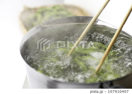 枝豆を鍋で茹でる 酒の肴に（ お酒のおつまみイメージ ）えだまめの塩茹で 豆 枝まめ 白バック ボイ 107910407