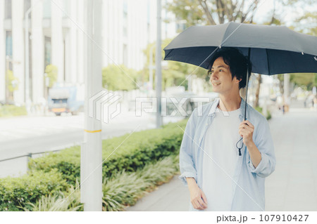 日傘をさす30代男性 107910427