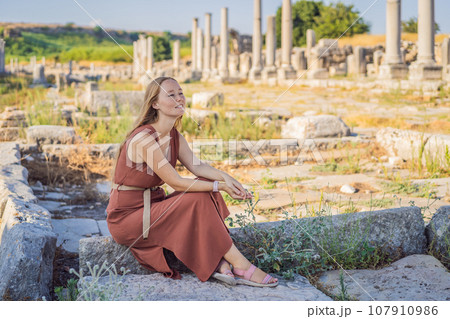 Pretty tourist woman at the ruins of ancient city of Perge near Antalya Turkey 107910986