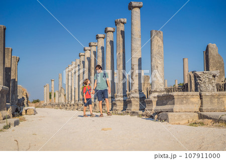 dad and son tourists at the ruins of ancient city of Perge near Antalya Turkey. Traveling with kids concept 107911000