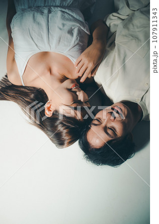 寝転ぶ男性と女性 寝転ぶ男性と女性 107911343