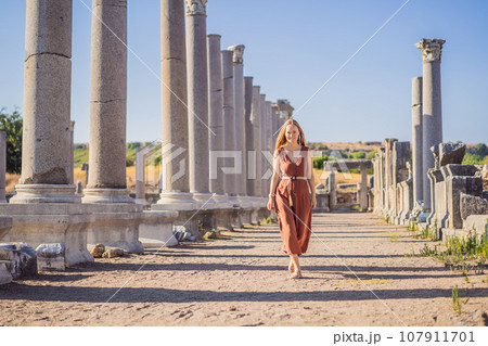 Pretty tourist woman at the ruins of ancient city of Perge near Antalya Turkey 107911701