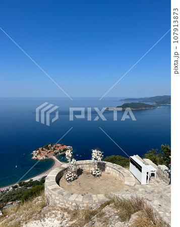 Piano and a wedding semi-arch stand on the observation deck above the island of Sveti Stefan. Montenegro Piano and a wedding semi-arch stand on the observation deck above the island of Sveti Stefan. Montenegro 107913873