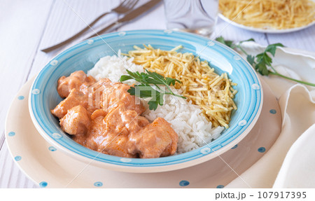 Chicken strogonoff in plate with rice and potato straw. Chicken strogonoff in plate with rice and potato straw. 107917395