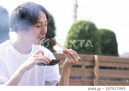 BBQで焼肉を楽しむ男性 107917865