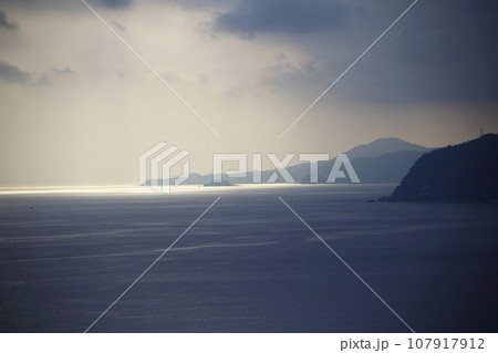 雲の切れ目からの光を受けて輝く幻想的な海 雲の切れ目からの光を受けて輝く幻想的な海 107917912