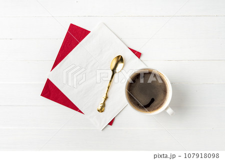Top view of coffee cup and paper napkins on wooden background Top view of coffee cup and paper napkins on wooden background 107918098