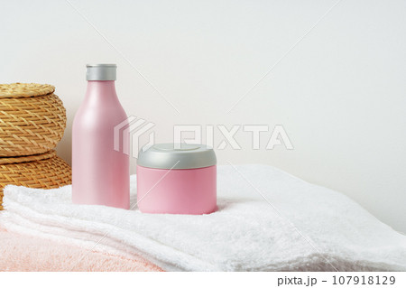 White cosmetics container mockup with towels on gray background 107918129