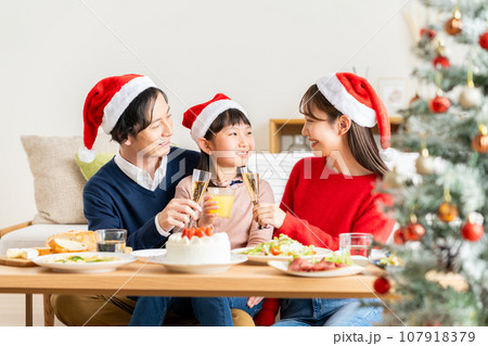 クリスマスにホームパーティーする若い家族 107918379