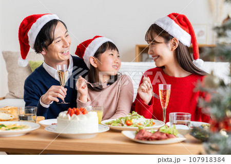 クリスマスにホームパーティーする若い家族 107918384