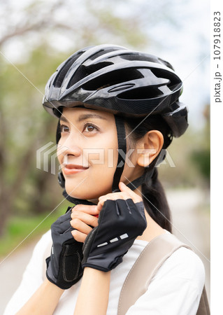 サイクリングヘルメットを被る若い女性 107918823