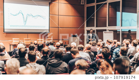Speaker giving a talk in conference hall at business event. Audience at the conference hall. Business and entrepreneurship. Speaker giving a talk in conference hall at business event. Audience at the conference hall. Business and entrepreneurship. 107919174