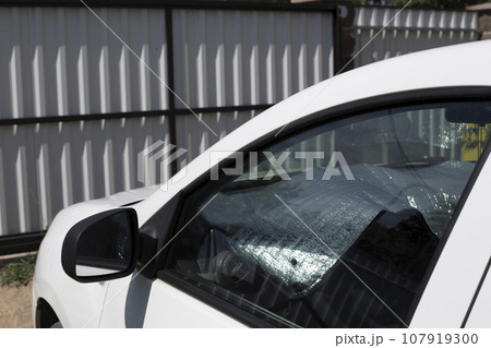 A sun reflector on the windshield of a car protects the car. 107919300