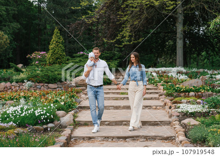 Loving happy family with a young son is having fun in a blooming spring park. Outdoor weekends Loving happy family with a young son is having fun in a blooming spring park. Outdoor weekends 107919548