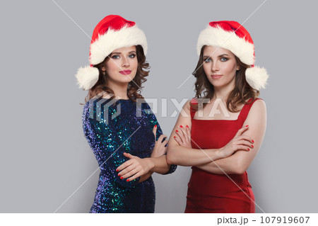 Beautiful glamorous Christmas women wearing red Santa hat, Xmas portrait 107919607