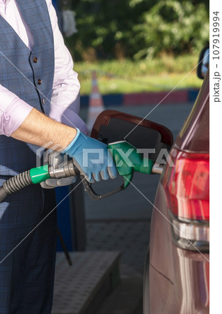 Car refueling on petrol station. Man pumping gasoline oil Car refueling on petrol station. Man pumping gasoline oil 107919994