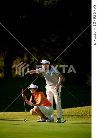 グリーン上でラインを読むカップル グリーン上でラインを読むカップル 107926795