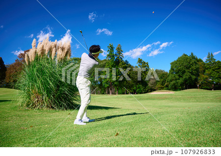 青空の中ゴルフをする40代男性 107926833