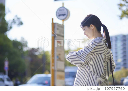 バス停でバスを待つ日本人の女性 107927760