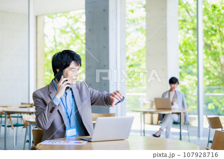 スマホで打合せするビジネスマン 107928716