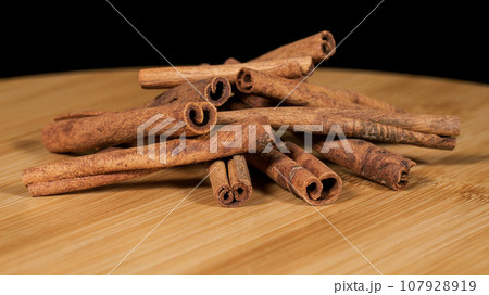 Close-up footage of cinnamon sticks on black background. Close-up footage of cinnamon sticks on black background. 107928919