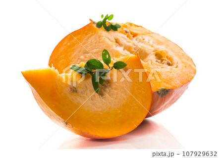 A piece of ripe orange pumpkin with seeds on a white background. 107929632