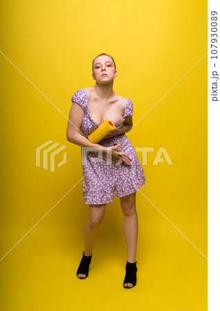 Beautiful female in underwear the wall with a roller. An attractive woman paints in studio. Beautiful female in underwear the wall with a roller. An attractive woman paints in studio. 107930089