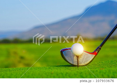 Golf ball and golf club on green in a beautiful golf course with morning sunshine. Golf ball and golf club on green in a beautiful golf course with morning sunshine. 107933676