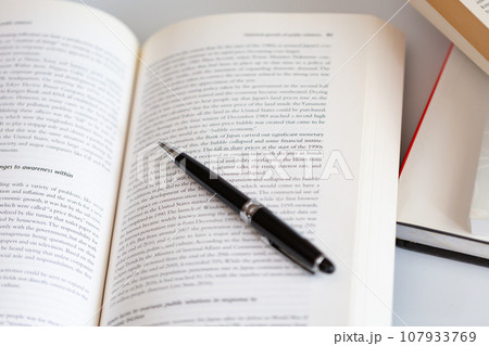 机の上に開いた英語の書籍とペン 研究 学習のイメージ 机の上に開いた英語の書籍とペン 研究 学習のイメージ 107933769
