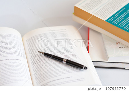机の上に開いた英語の書籍とペン 研究 学習のイメージ 107933770