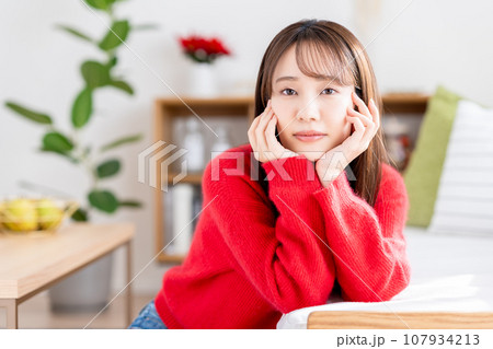 リビングでくつろぐ若い女性 リビングでくつろぐ若い女性 107934213