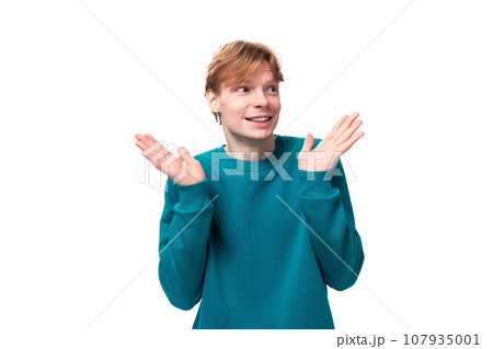 young cheerful handsome man with red hair dressed in a blue jacket on a white background with copy 107935001