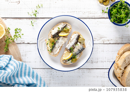 Sardines sandwiches on a white wooden background. Mediterranean food. Top view 107935838