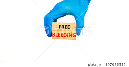 Free bleeding symbol. Concept words Free bleeding on beautiful wooden block. Beautiful white table white background. Doctor hand. Gen Z, motivational, freedom free bleeding concept. Copy space. 107936552