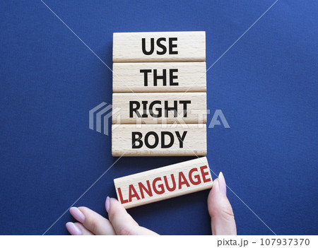 Use the righ Body Language symbol. Concept words Use the righ Body Language on wooden blocks. Businessman hand. Beautiful deep blue background. Business concept. Copy space Use the righ Body Language symbol. Concept words Use the righ Body Language on wooden blocks. Businessman hand. Beautiful deep blue background. Business concept. Copy space 107937370