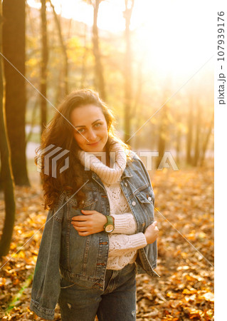 Stylish woman posing in the autumn forest at sunset. Lifestyle. High fashion portrait. Stylish woman posing in the autumn forest at sunset. Lifestyle. High fashion portrait. 107939176