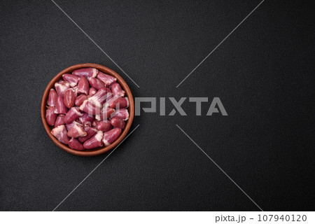 Fresh raw chicken, turkey or duck hearts on a ceramic plate with salt and spices Fresh raw chicken, turkey or duck hearts on a ceramic plate with salt and spices 107940120