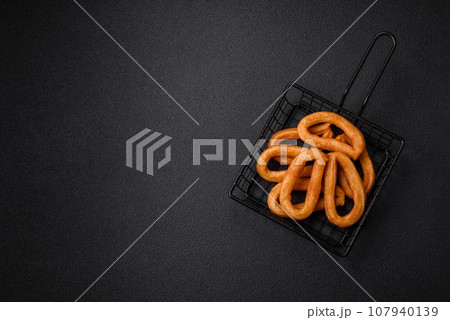 Delicious sweet churos with powdered sugar and cream inside 107940139