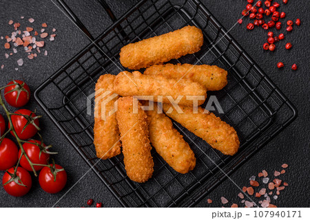 Delicious crispy cheese sticks with mozzarella, salt and spices, breaded Delicious crispy cheese sticks with mozzarella, salt and spices, breaded 107940171