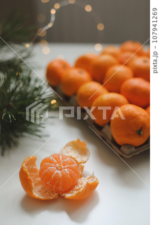 Christmas background with fir tree branches and tangerines. Merry Christmas and Happy New Year Greeting Card Christmas background with fir tree branches and tangerines. Merry Christmas and Happy New Year Greeting Card 107941269