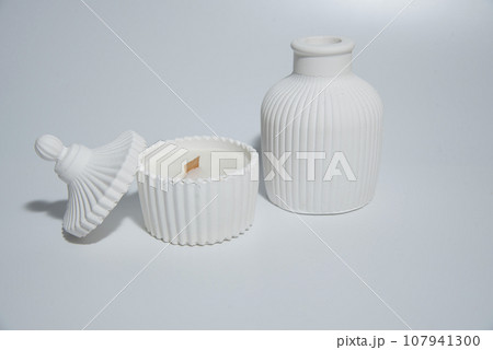 Home made candle in white ceramic pot on a white background ,a vase with a candle 107941300