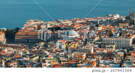 Naples, Italy. Top View Cityscape Skyline With Famous Landmarks And Part Of Gulf Of Naples With Ship In Sunny Day. Many Old Churches And Temples 107941309