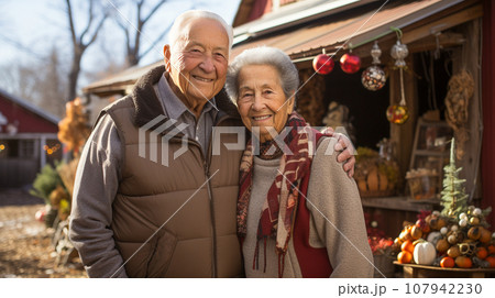 An Affectionate Happy Senior Couple Standing In Front of Their Christmas Cabin Shop with Holiday Items. 107942230