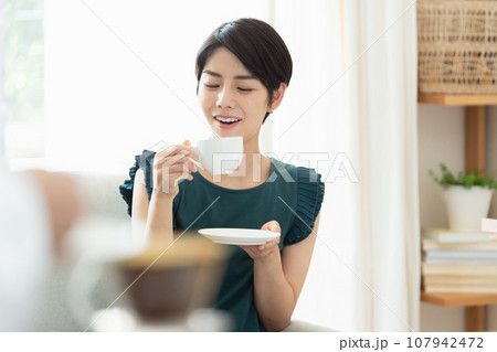 リビングでコーヒーを飲む女性 リビングでコーヒーを飲む女性 107942472