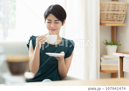 リビングでコーヒーを飲む女性 リビングでコーヒーを飲む女性 107942474