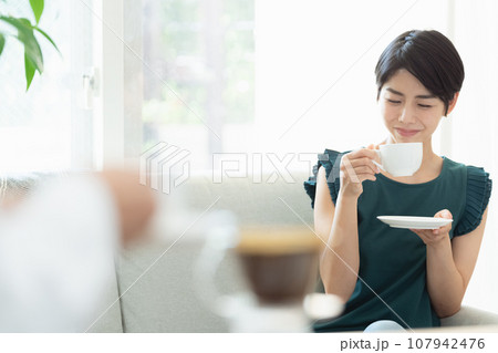 リビングでコーヒーを飲む女性 リビングでコーヒーを飲む女性 107942476