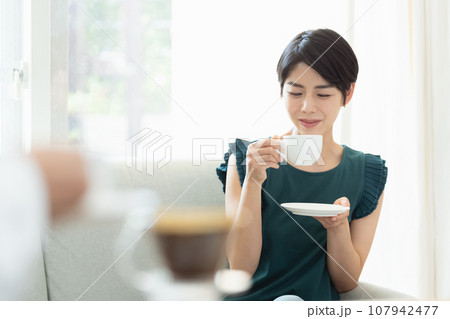 リビングでコーヒーを飲む女性 リビングでコーヒーを飲む女性 107942477