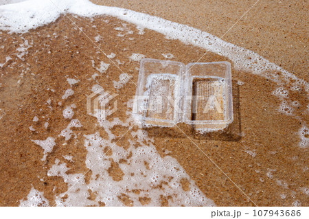 Plastic food container on the beach 107943686